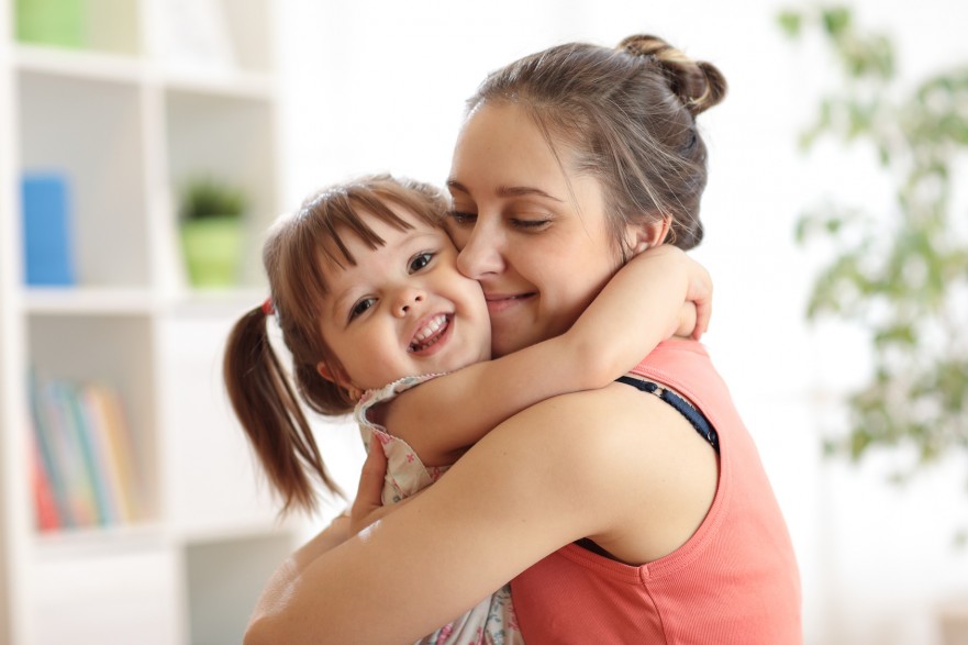 love and family people concept - happy mother and child daughter hugging at home